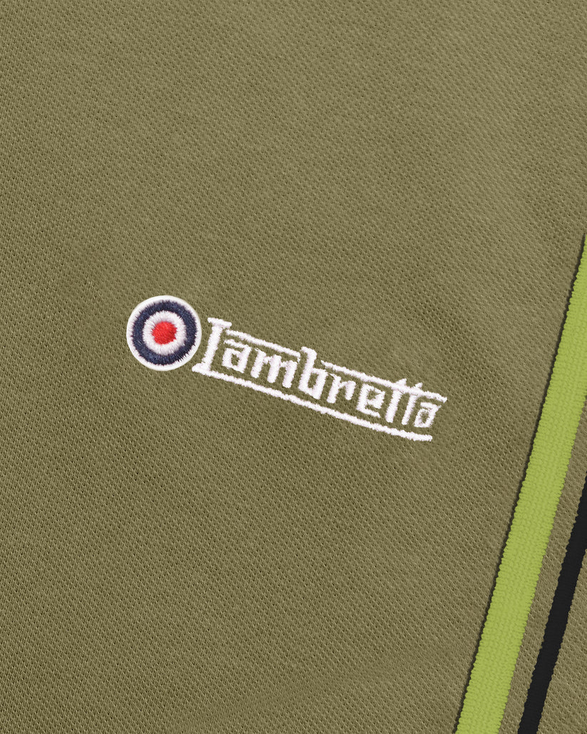 Close-up of olive green fabric with a white embroidered Lambretta logo and a red, white, and blue target emblem.