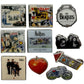 A set of nine The Beatles collectible enamel pins and badge designs arranged on a plain white background, featuring album art, band photos, a bicycle, a heart, and a drum motif.