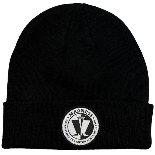 A black knit beanie hat with a folded cuff, featuring a circular white and black embroidered patch on the front that reads 'MADNESS' and includes a stylized M' emblem.