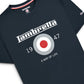 A close-up of a dark navy blue t-shirt featuring a white and red graphic print. The design includes the word 'Lambrella' in a stylized font, a circular target emblem with red, white, and gray, the numbers '1947', and the phrase 'A WAY OF LIFE'.