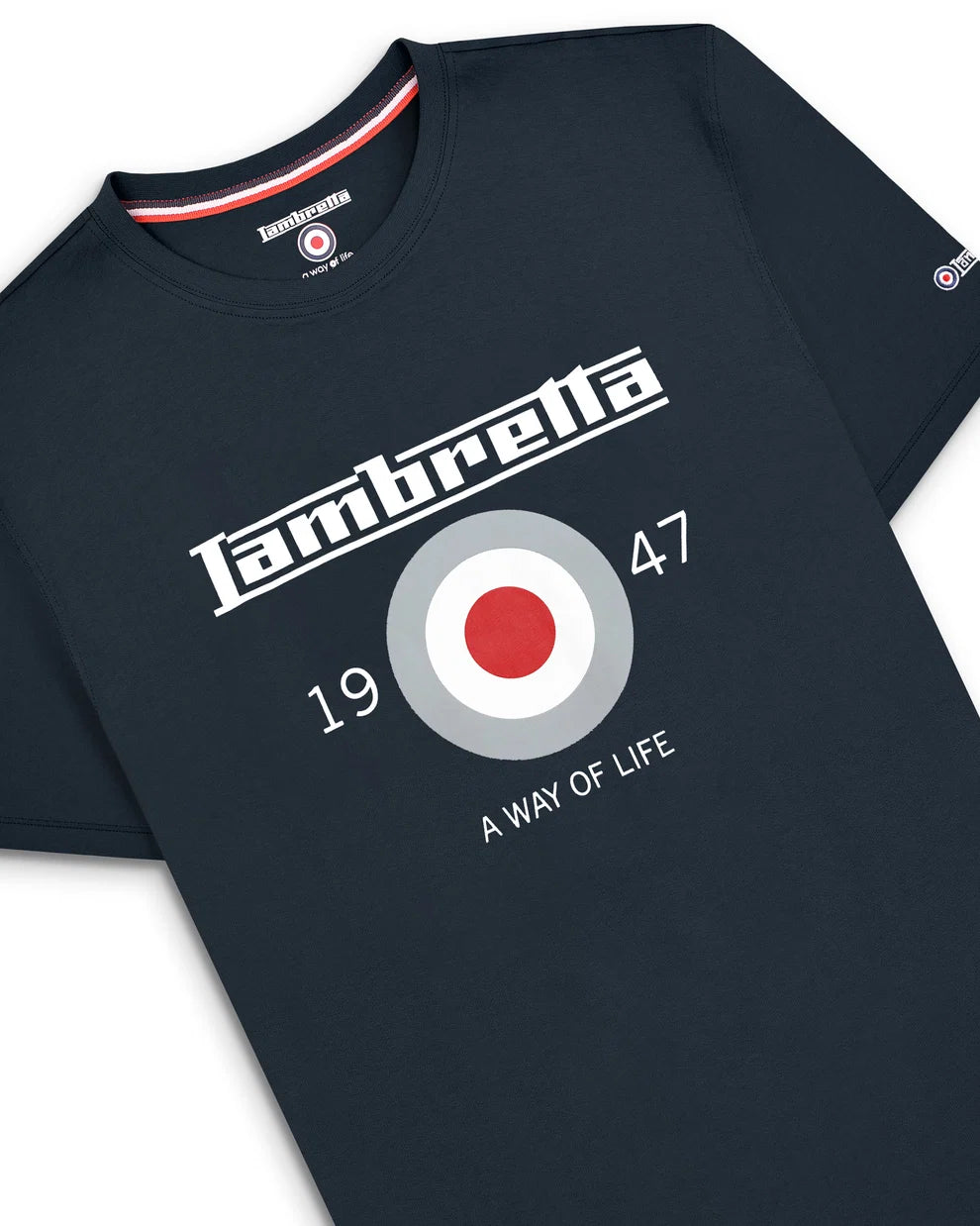 A close-up of a dark navy blue t-shirt featuring a white and red graphic print. The design includes the word 'Lambrella' in a stylized font, a circular target emblem with red, white, and gray, the numbers '1947', and the phrase 'A WAY OF LIFE'.