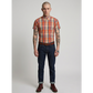 Man wearing a plaid shirt, jeans, and boots on a plain background