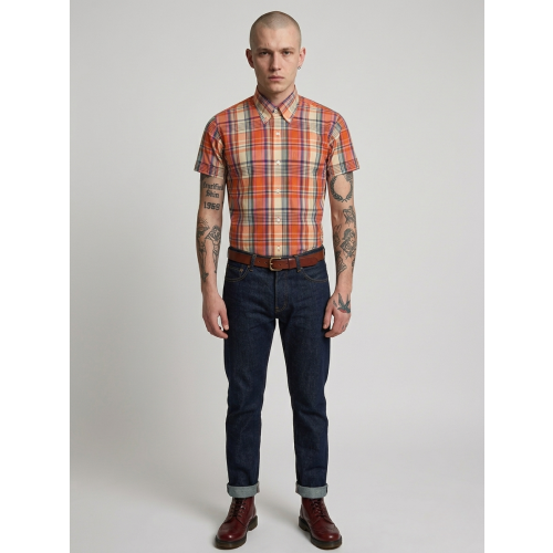 Man wearing a plaid shirt, jeans, and boots on a plain background