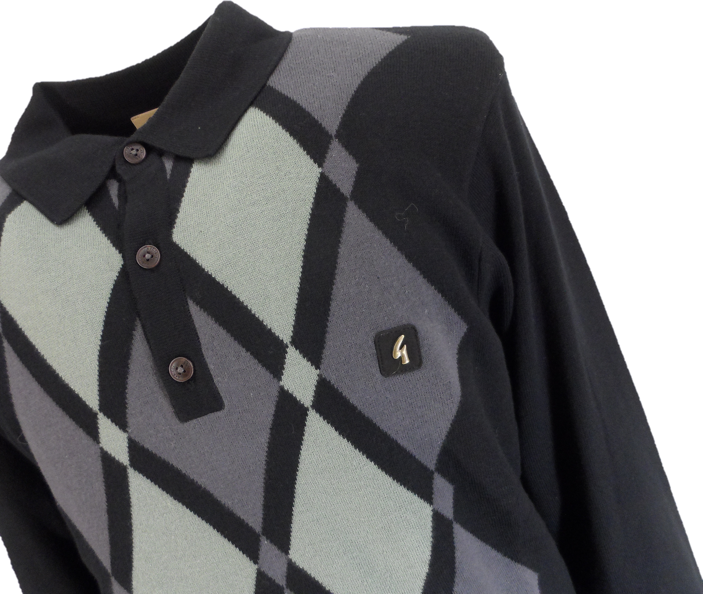 A close-up of a long-sleeve knit polo shirt featuring a diamond argyle pattern in black, gray, and pale sage green, with a small gold logo patch on the chest.