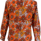 A long-sleeve button-up shirt with a retro 1970s floral pattern in orange, brown, and beige on a white background.