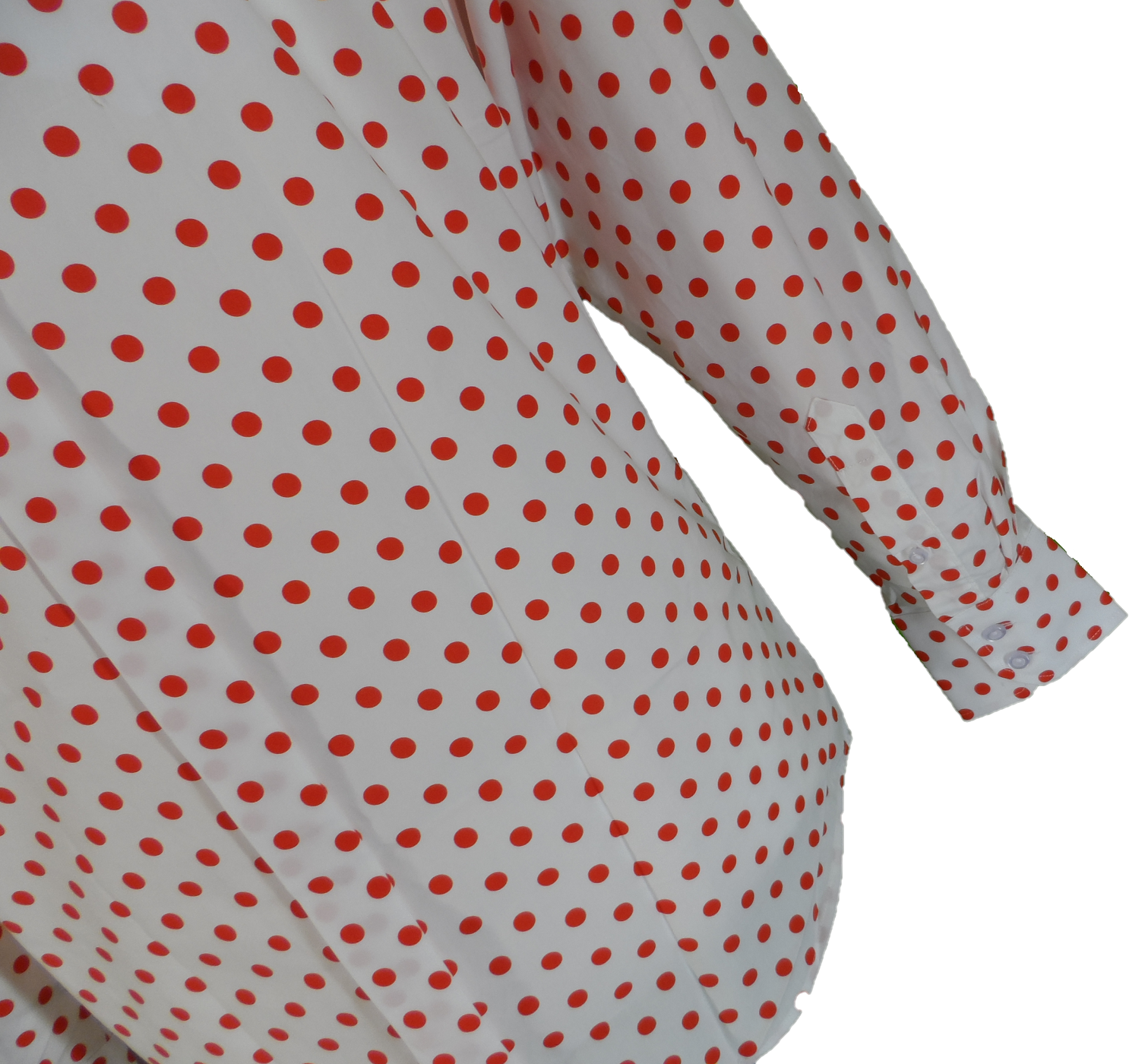 A close-up of a white long-sleeve blouse or dress with a red polka dot pattern, showing the fabric texture and a cuff on a plain white background.