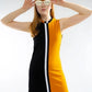 Woman wearing a black and yellow dress with white stripes on a plain background