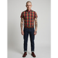 Man wearing a plaid shirt, jeans, and boots on a plain background