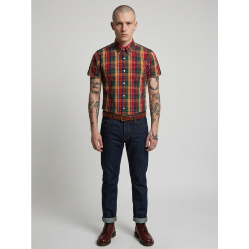 Man wearing a plaid shirt, jeans, and boots on a plain background